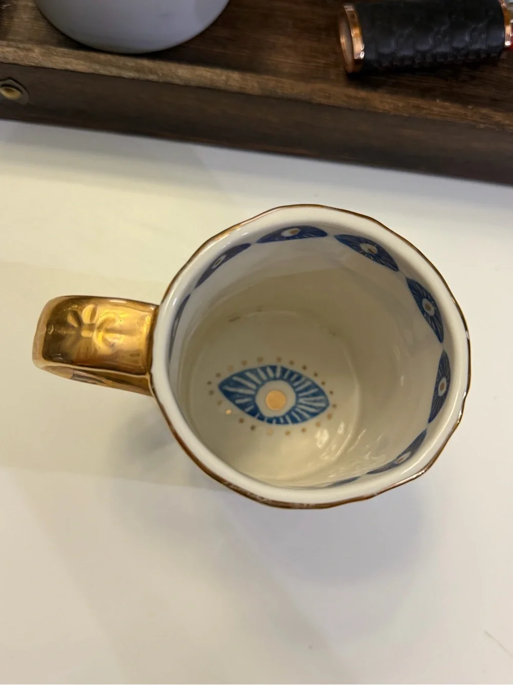 Anthropologie White Ceramic Mug with Blue Eye Motif and Gold Trim